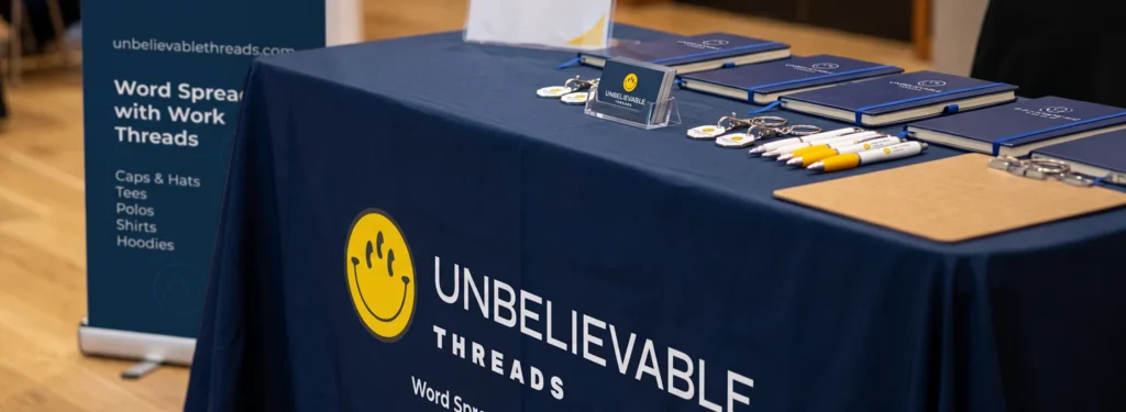 Exhibition stand essentials including roller banner, branded table cloth, workwear, lanyard and business cards.